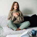 Women grabbing her chest as if she cannot breathe